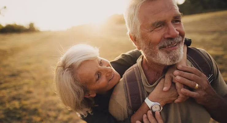 Couple de retraités heureux dans un champ